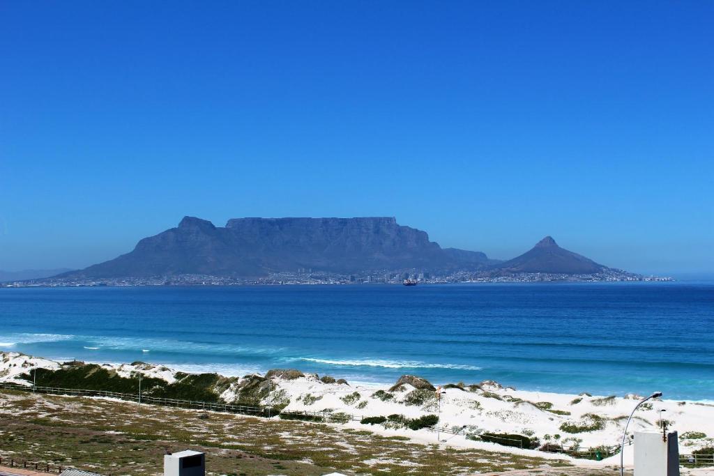a view of the ocean with mountains in the background at 605 Nautica in Bloubergstrand