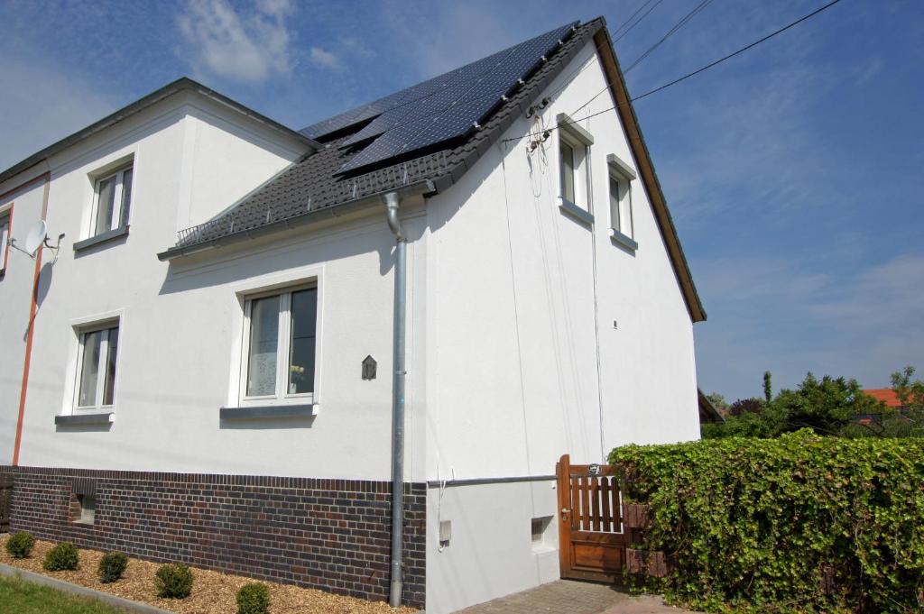 una casa blanca con techo negro en Ferienhaus Halbritter Pouch, en Pouch