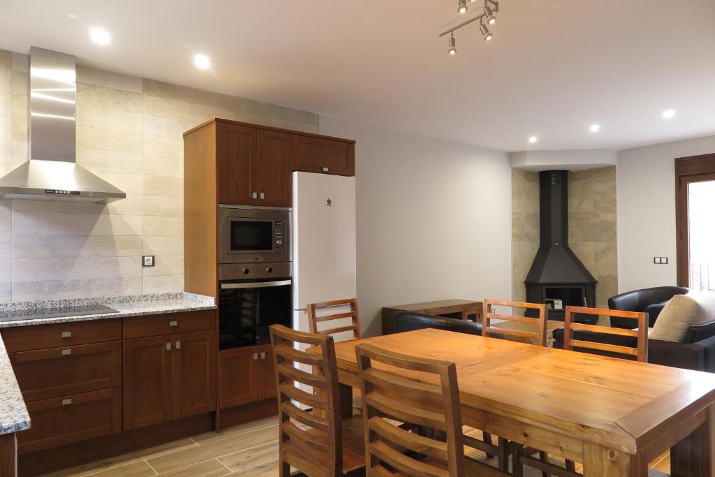 Casa Bielsa في بييلسا: مطبخ وغرفة طعام مع طاولة خشبية