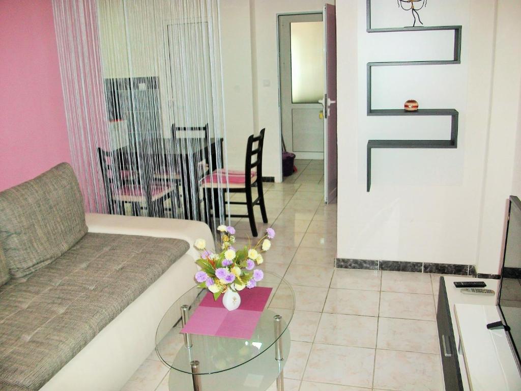 a living room with a couch and a table with flowers at Apartments Petrovic in Krimovice