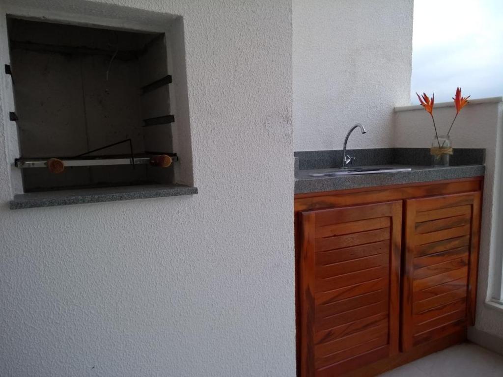 a kitchen with a sink and a counter top at Condominio Garden Indaia in Caraguatatuba