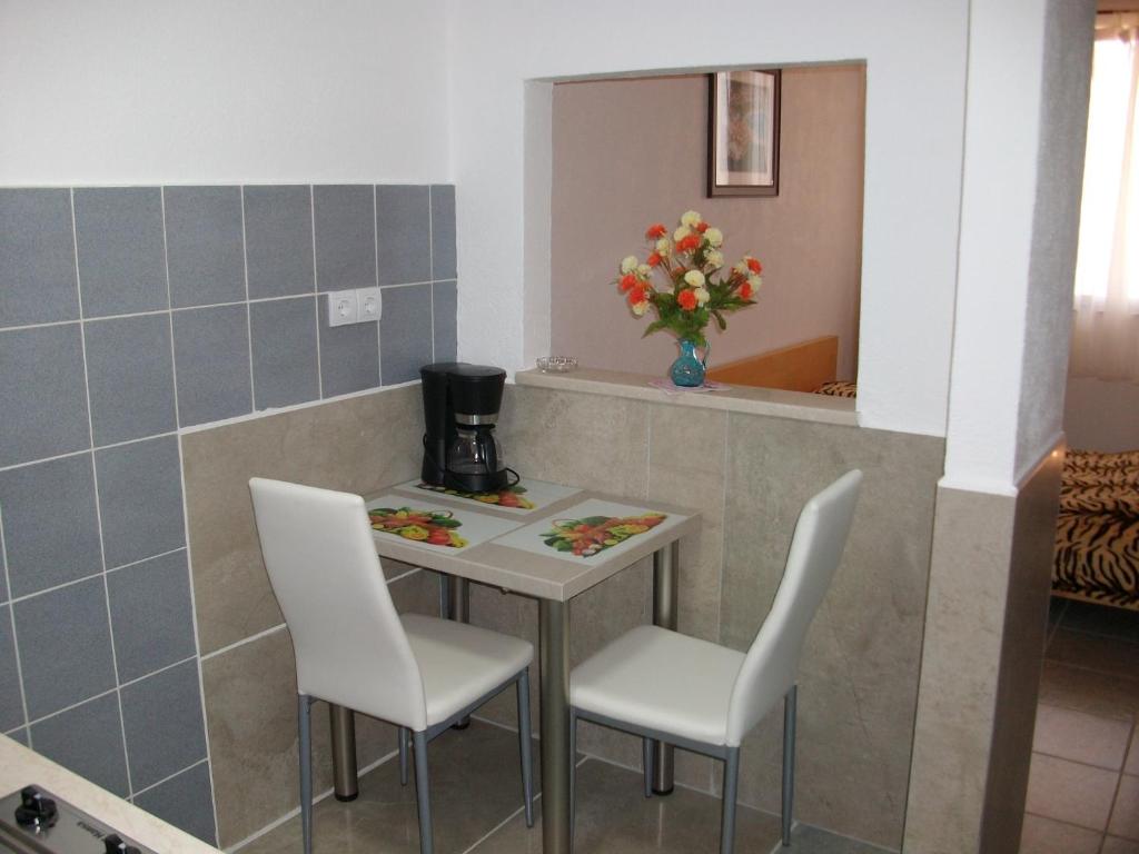 a small table with two chairs and a coffee maker at Apartments Petrovic in Krimovice