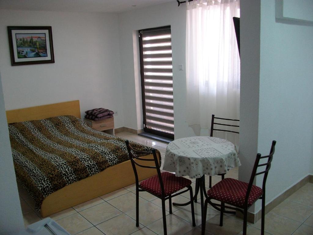 a bedroom with a bed and a table and chairs at Apartments Petrovic in Krimovice