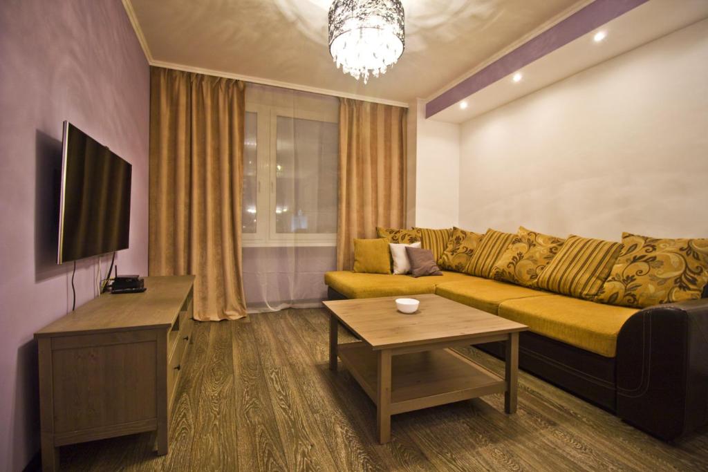 モスクワにあるLakshmi Apartment Novy Arbat 1kのリビングルーム(ソファ、テーブル付)