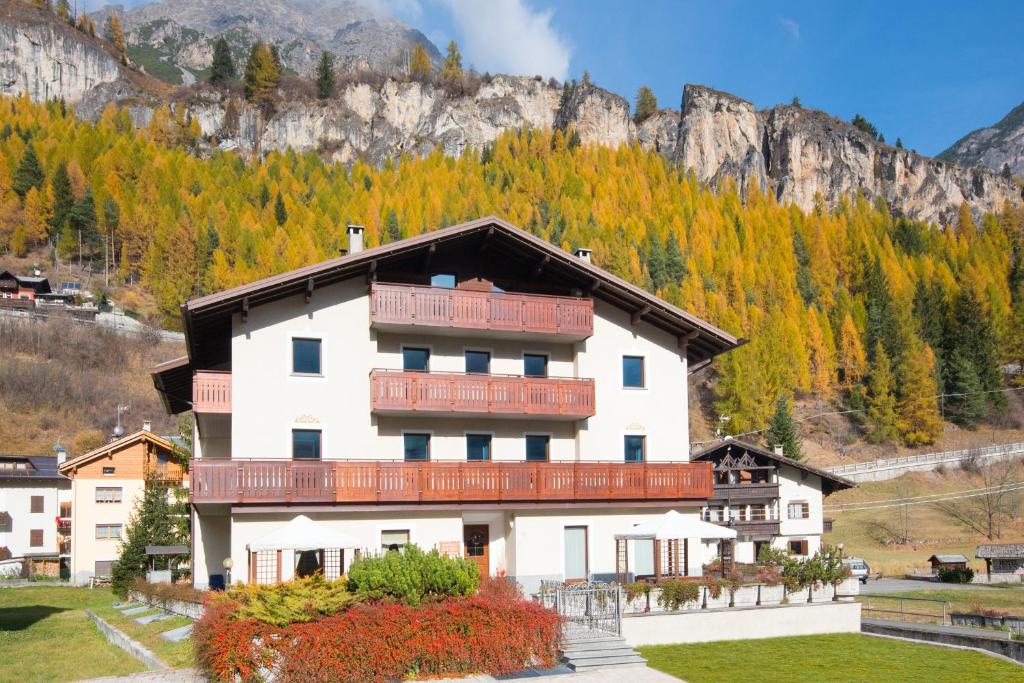 un grande edificio bianco con balconi rossi di Casa Martinelli Holiday Home a Valdidentro