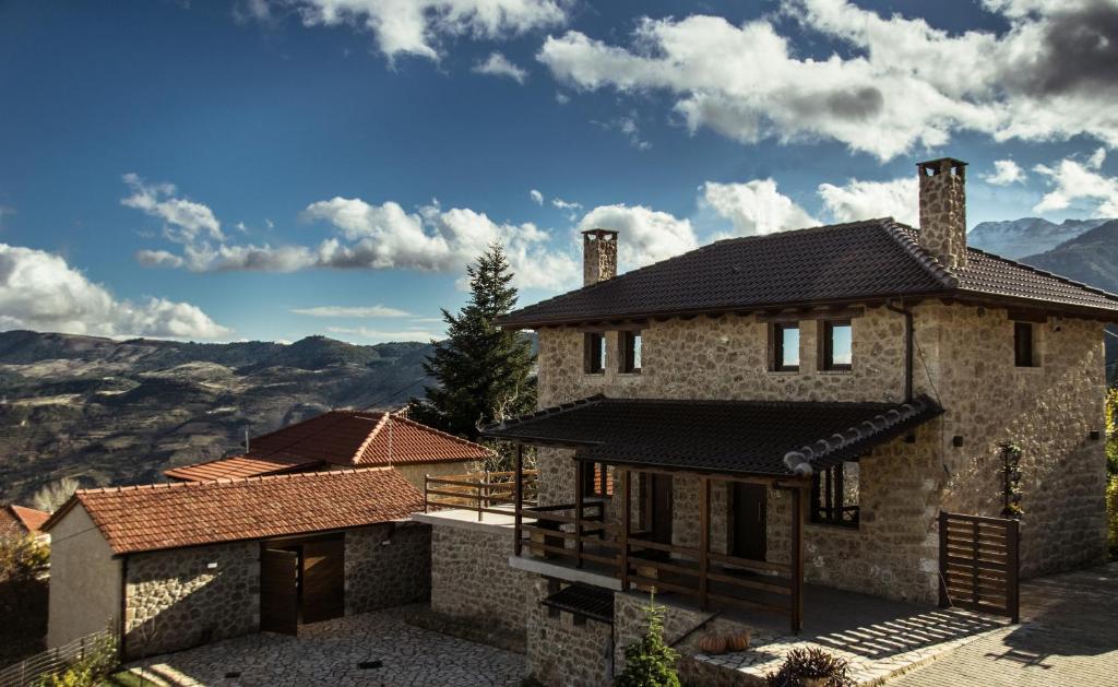 ein Steinhaus mit Bergblick in der Unterkunft Anotopos in Ano Trikala