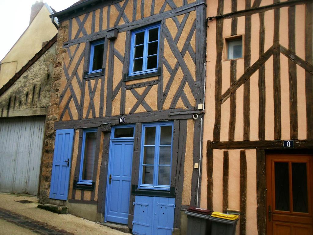 stary budynek z niebieskimi drzwiami i oknami w obiekcie La maison bleue w mieście Nogent-sur-Seine