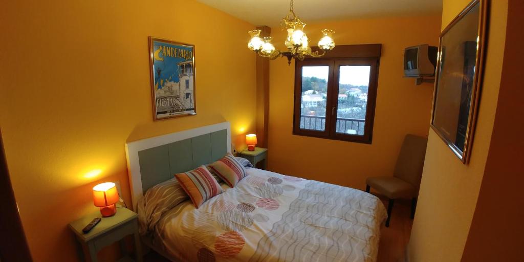 a bedroom with a bed and a window and a chandelier at Casa Sierra in Candelario