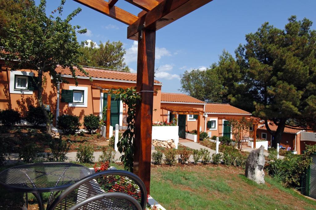 a view of a house with a bench in the yard at Koversada Apartments Naturist Park in Vrsar