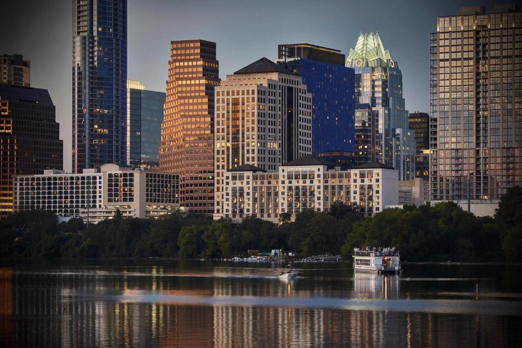 a city skyline with a river and a boat in the water at Four Seasons Hotel Austin in Austin