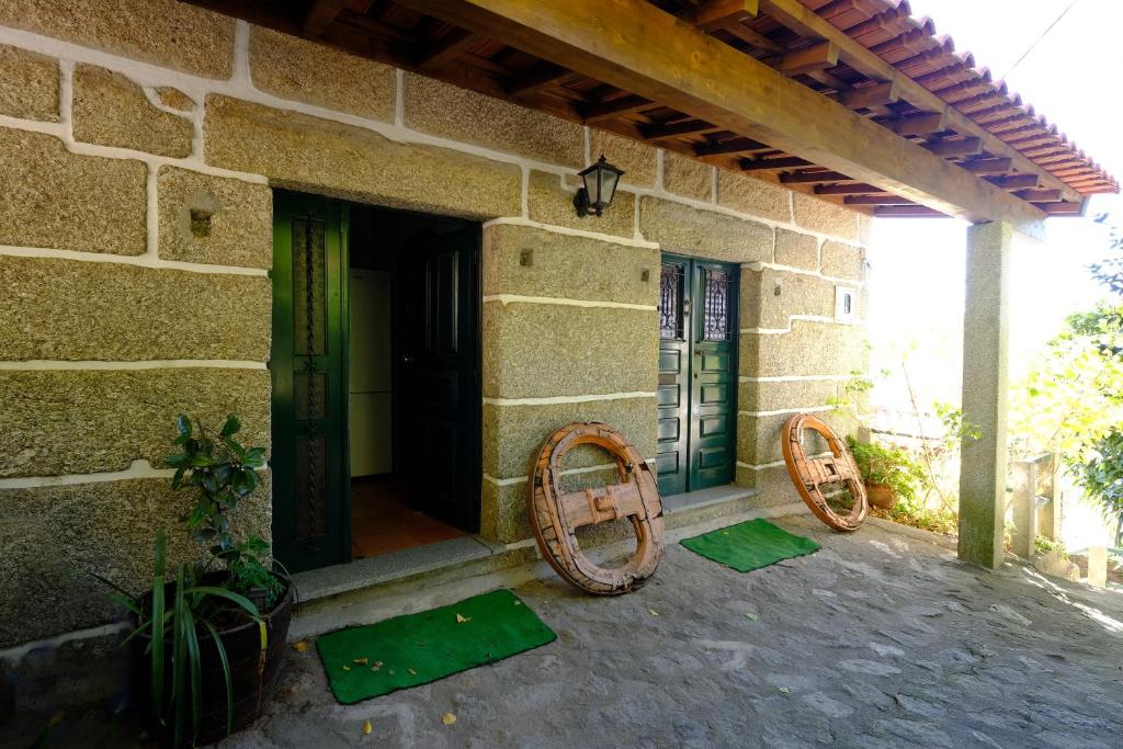 une maison en pierre avec 2 roues boisées sur une terrasse dans l'établissement Casas do Casinhoto - Casa do Cabo, à Baião