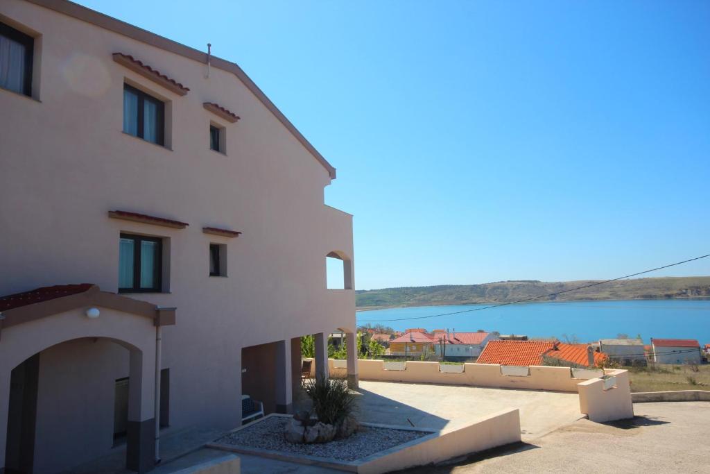 un edificio blanco con vistas al agua en Apartments Njaco, en Ražanac
