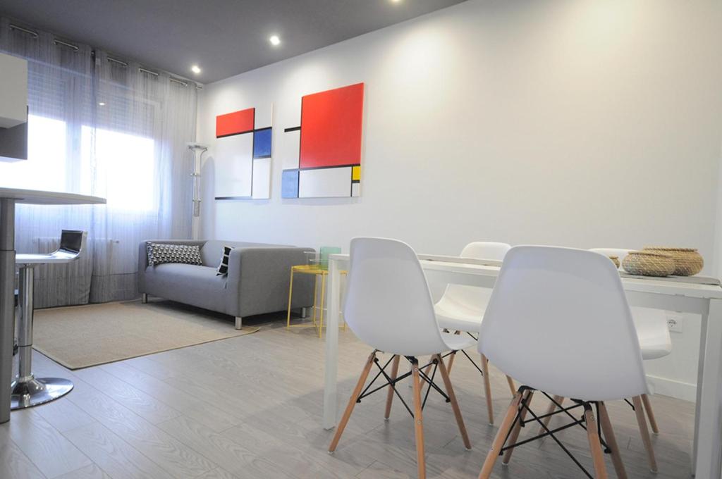 el11 apartamento في سمورة: غرفة معيشة مع كراسي بيضاء وطاولة