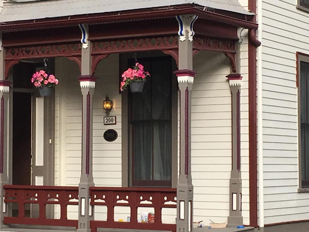 eine Veranda eines Hauses mit Blumen darauf in der Unterkunft Rose Street Bed & Breakfast in Georgetown