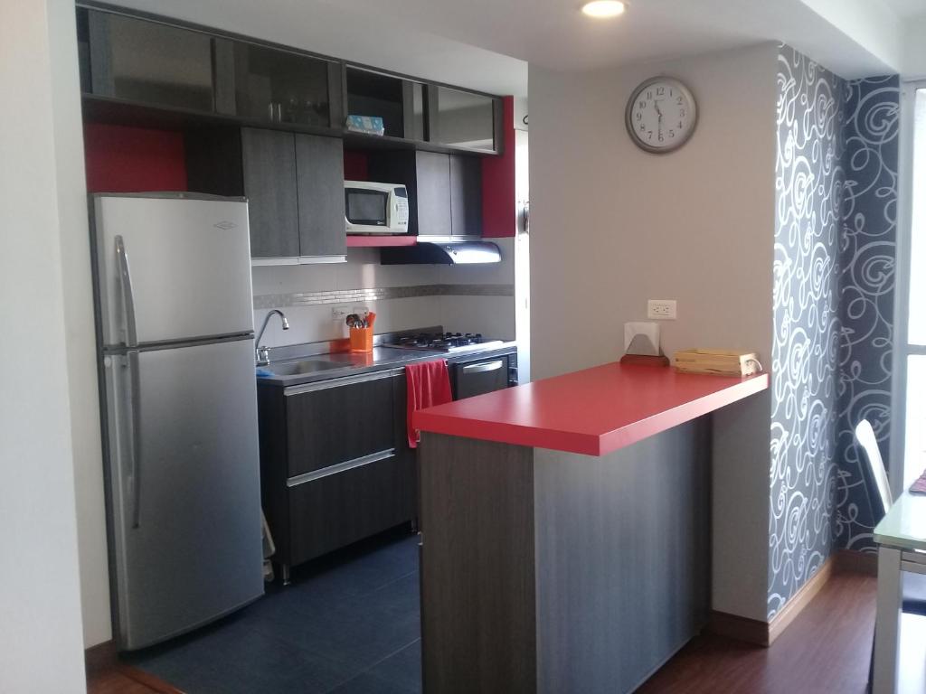 a kitchen with a refrigerator and a red counter top at Apartamento En Sabaneta in Sabaneta