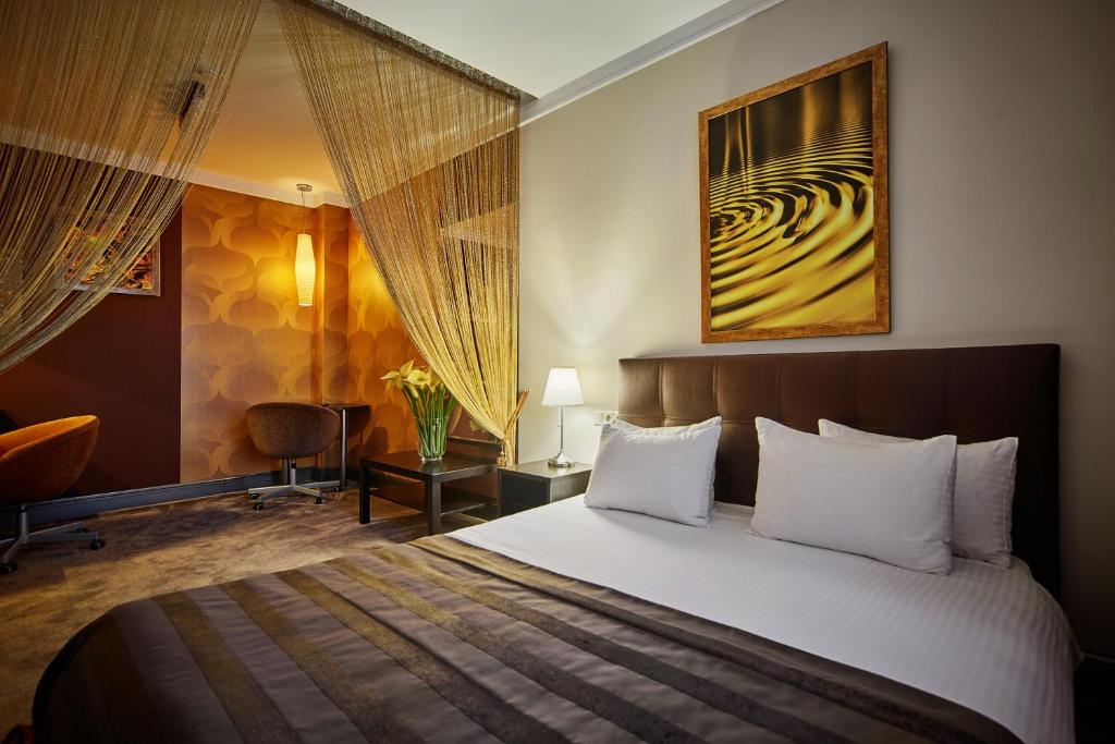 Habitación de hotel con cama y silla en Art Hotel, en Surgut