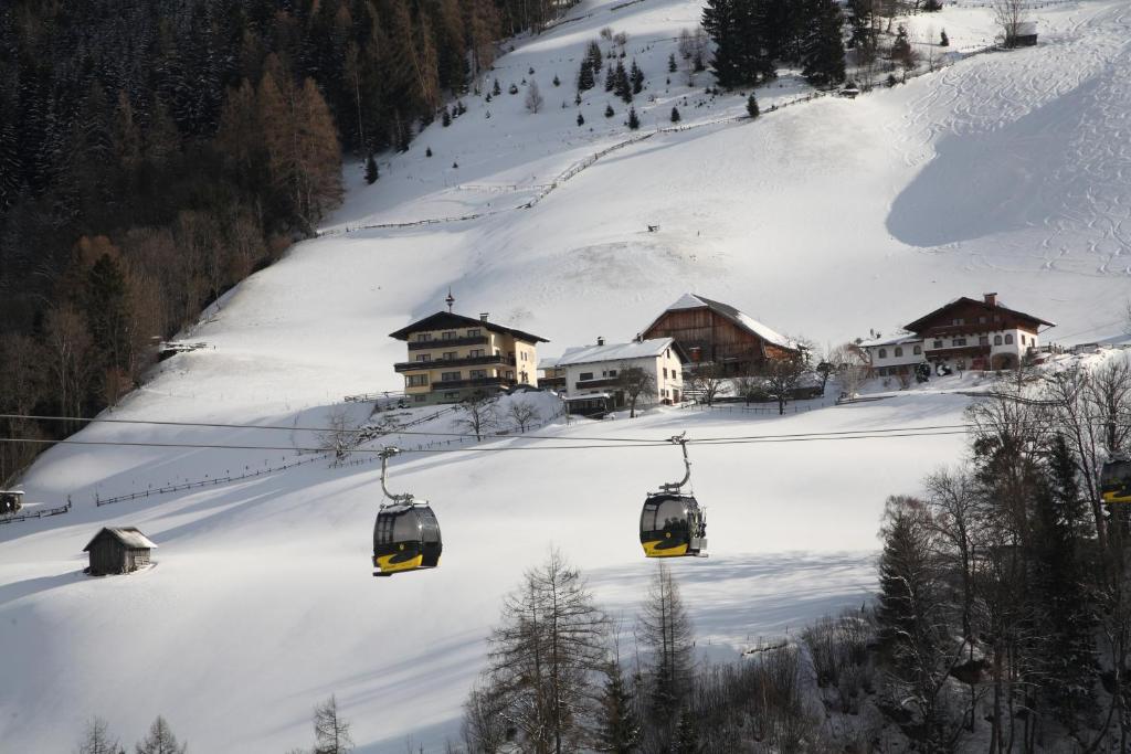 a couple of ski lifts going down a snow covered slope at Pension Spreitzhof & Appartement Royer in Schladming