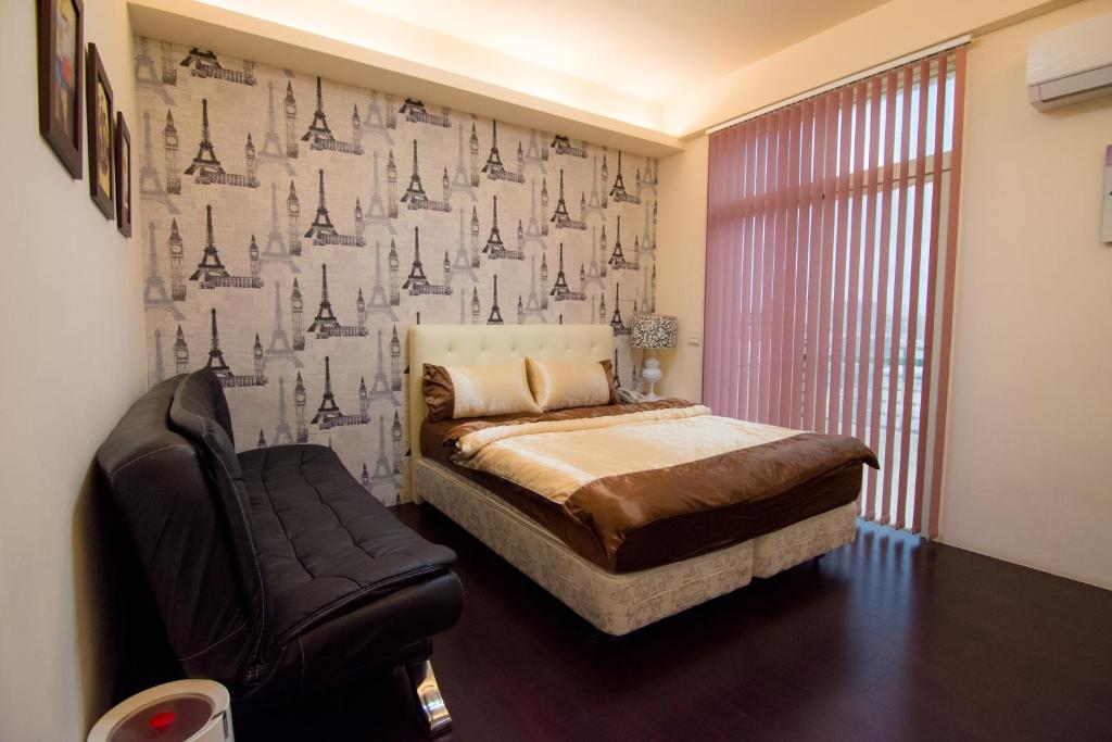 馬公市的住宿－達日好民宿 ，一间卧室配有一张床、一把椅子和壁纸