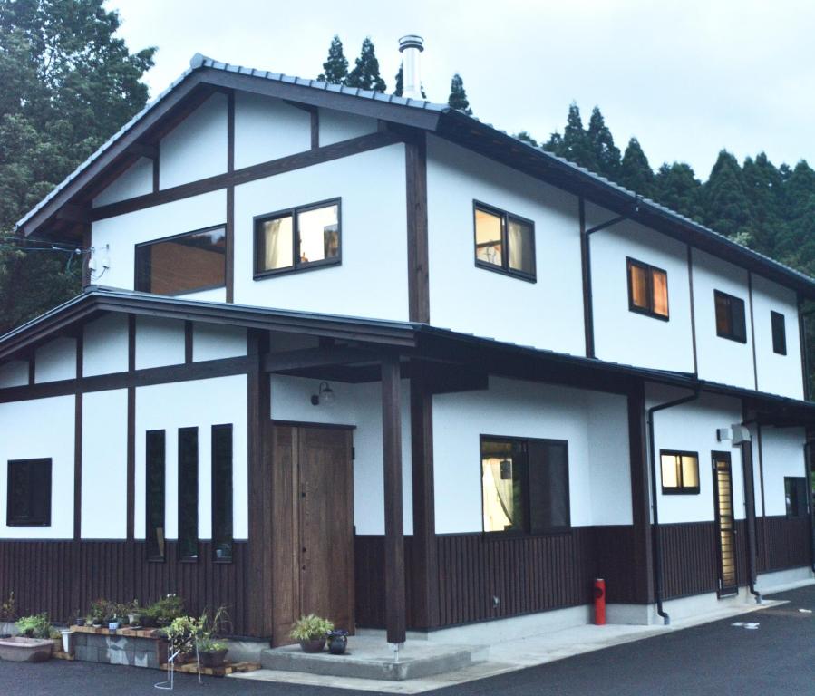 une maison blanche avec beaucoup de fenêtres dans l'établissement Wakka, à Minami Aso