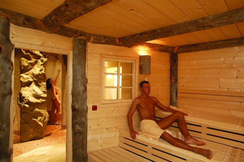a man sitting in a sauna in a cabin at Amselgrundschlösschen in Kurort Rathen