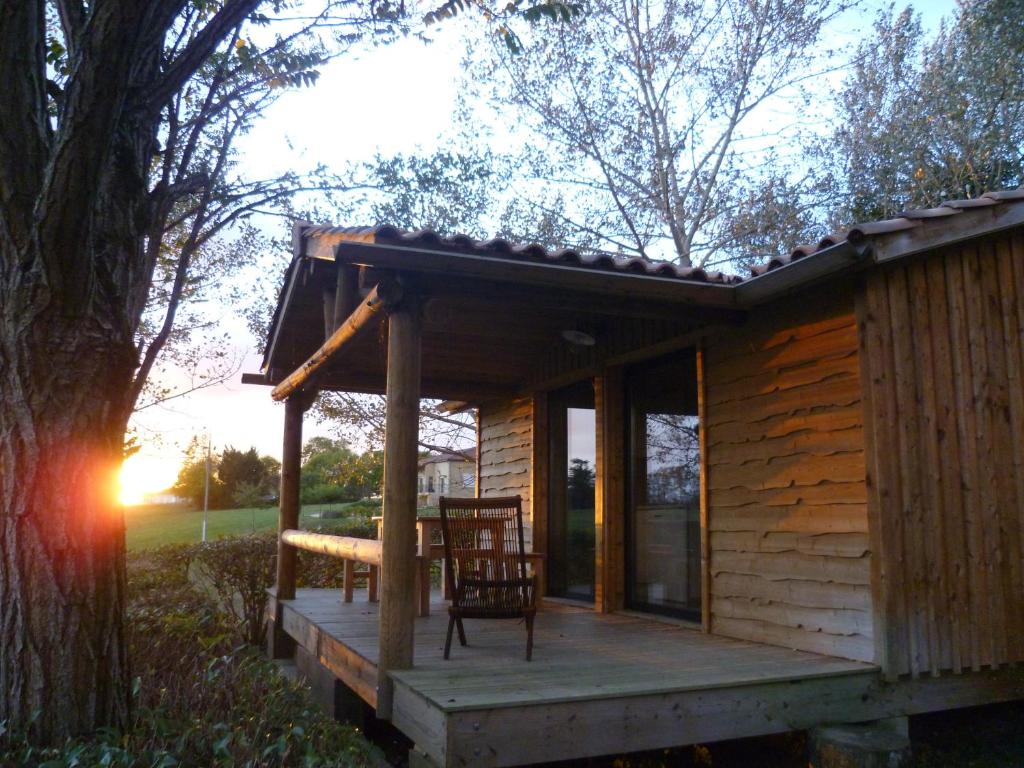 a cabin with a table and a chair on a deck at Camping Pré-Fixe in Cassagnabère-Tournas
