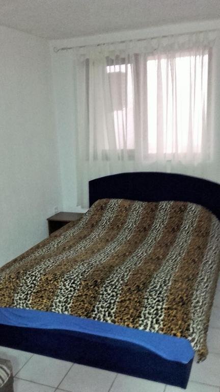 a bed in a bedroom with a leopard print bedspread at Apartments Petrovic in Krimovice