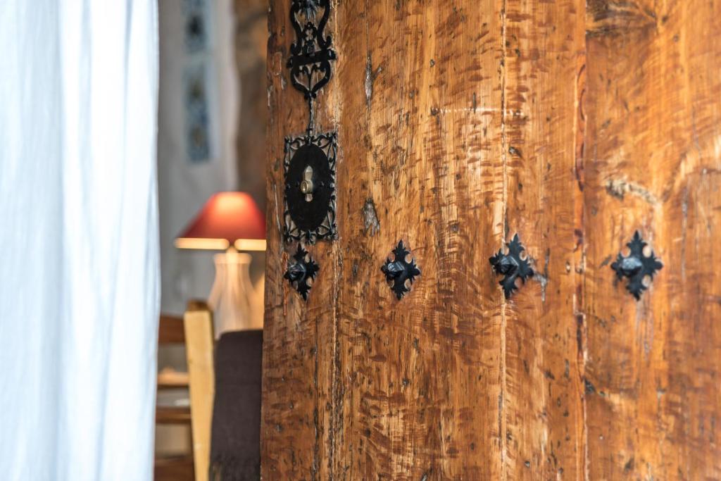 a wooden wall with black embellishment on it with a lamp at L'Arc de Pedra in Vilafamés