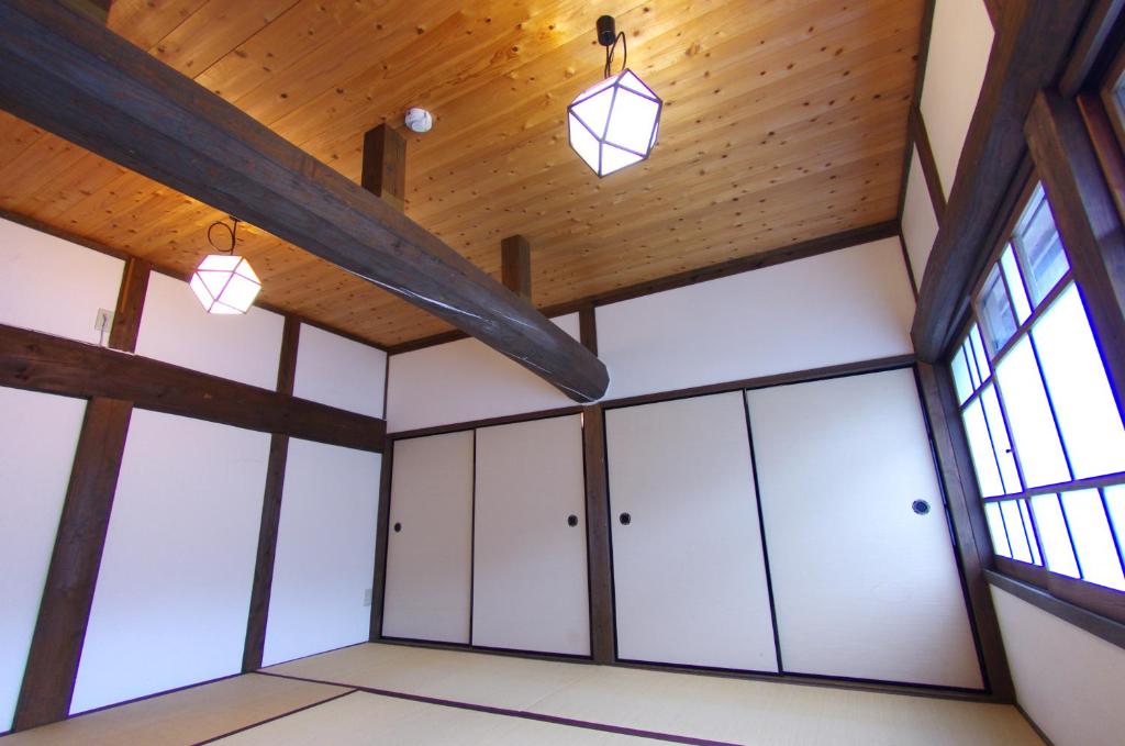 a room with white cabinets and wood ceilings at Akitsuki Kominka Yado You in Asakura