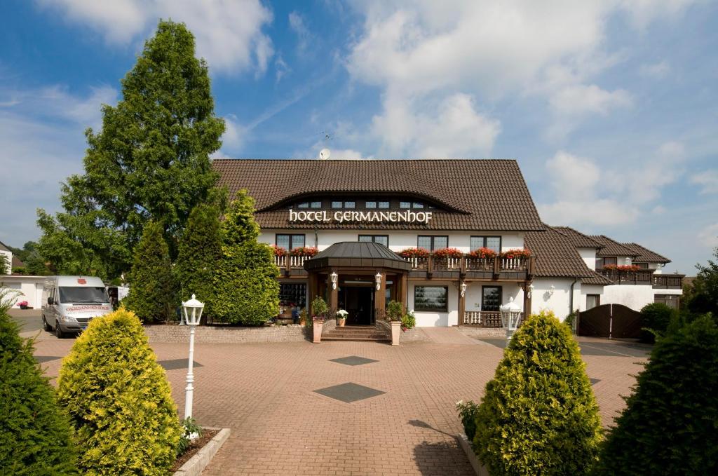 ein Hotel mit einem Baum vor einem Gebäude in der Unterkunft Germanenhof in Sandebeck