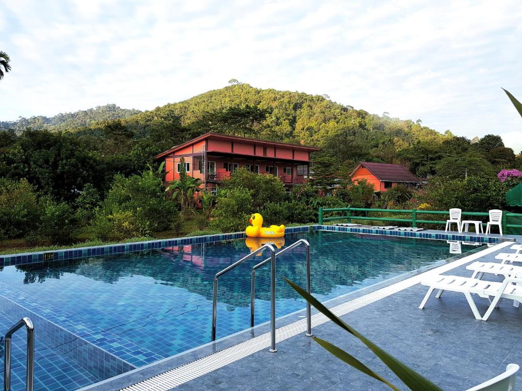 een zwembad voor een huis met een berg bij Khao Sok Country Resort in Khao Sok
