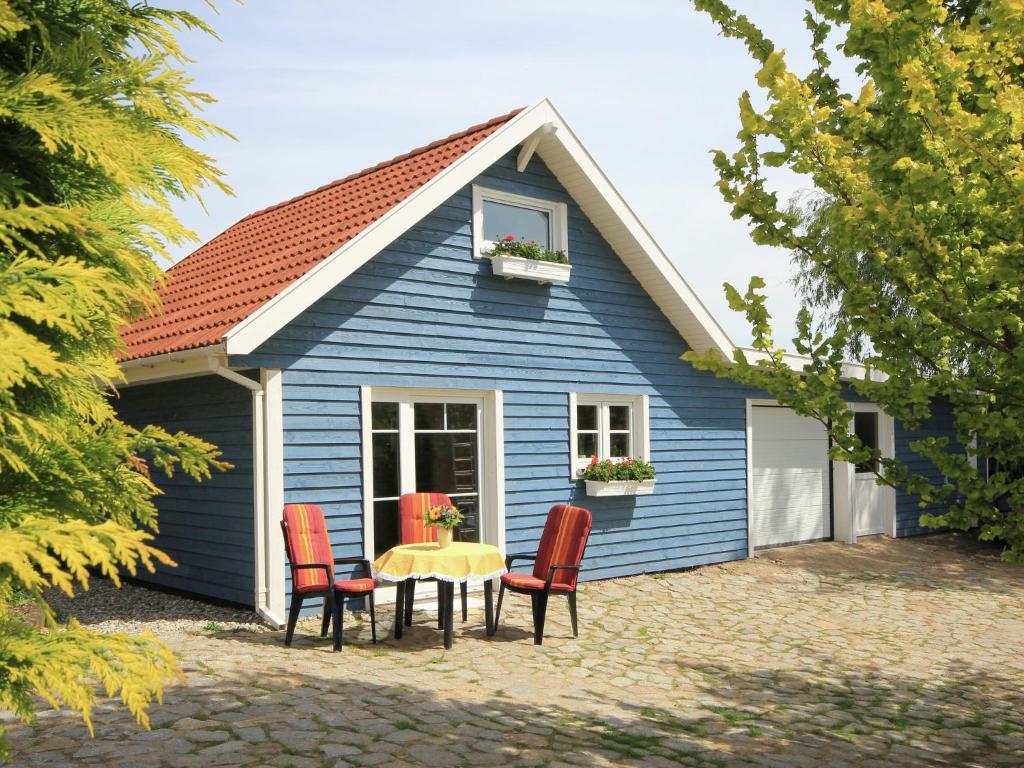 a blue house with a table and chairs in front of it at Modern Holiday Home in Steffenshagen with Terrace in Steffenshagen