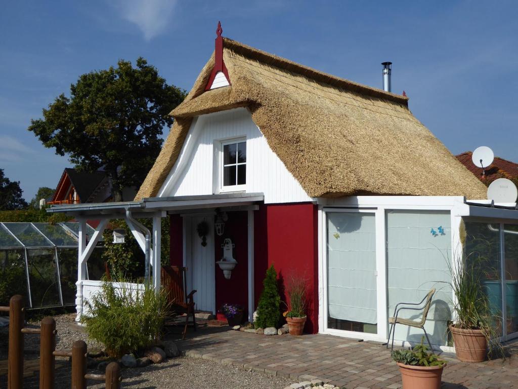 a thatch roof cottage with a garage at Quaint Holiday Home in Schwaan near the Lake in Schwaan