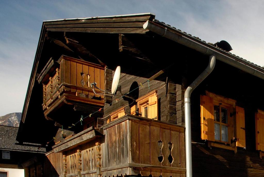 Cette maison en bois dispose d'un balcon sur le côté. dans l'établissement Ferienhaus Posthüttl, à Virgen