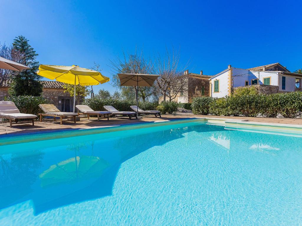una gran piscina con sillas y sombrilla en Belvilla by OYO Villa 13, en Consell