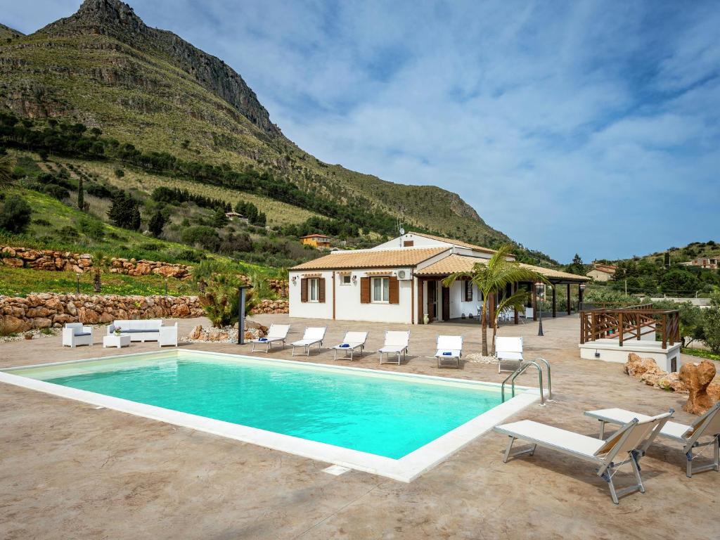 a villa with a swimming pool in front of a mountain at Belvilla by OYO Mari e Monti 4 in Castellammare del Golfo