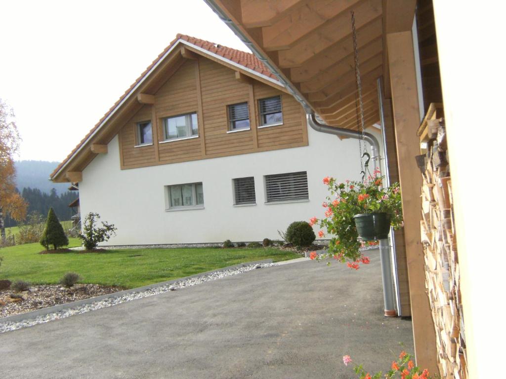 una casa con una entrada delante de ella en BnB Niederer en La Côte-aux-Fées