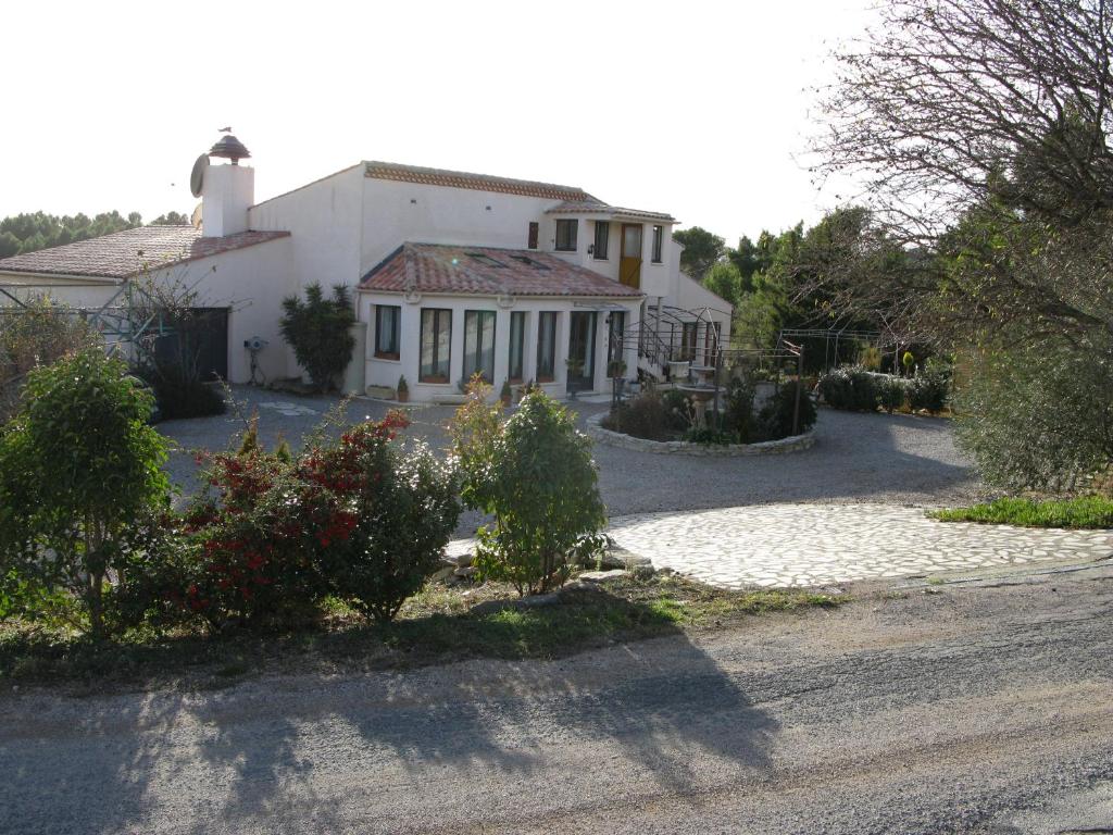 a large white house with a driveway at Mas a 4 Mains in Cesseras