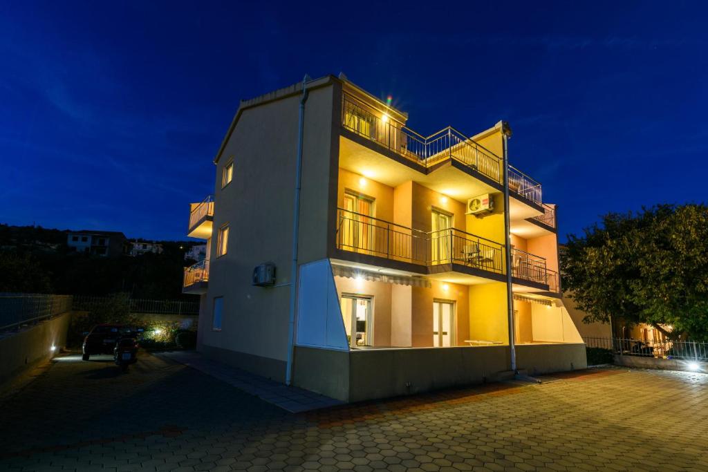 a large white building with a balcony at night at Apartments Neve in Marina