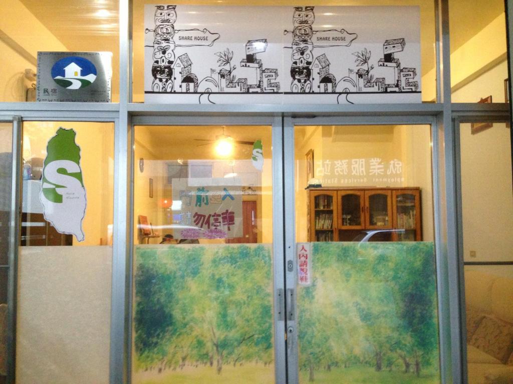 a building with glass doors and signs on the wall at Handy Hostel in Hualien City