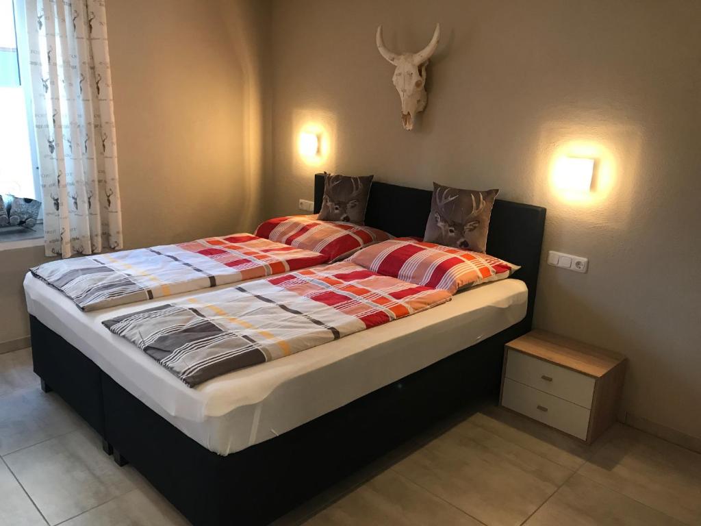 a large bed in a bedroom with a antelope skull on the wall at Kössen DORF41 TOP2 in Kössen