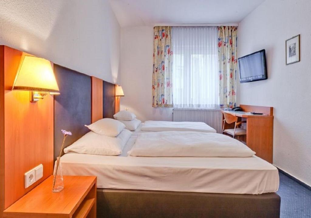Postel nebo postele na pokoji v ubytování Hotel am Friedensplatz