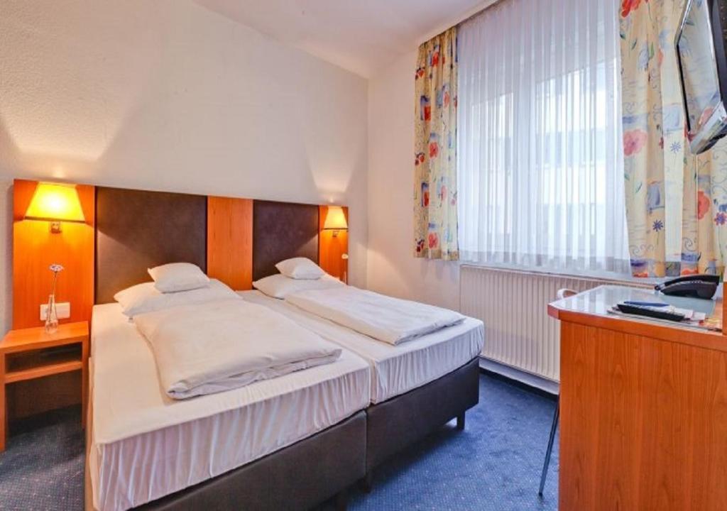 Postel nebo postele na pokoji v ubytování Hotel am Friedensplatz