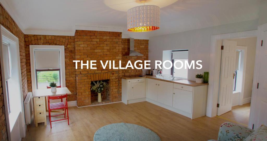 a kitchen with a table and a brick wall at The Village Rooms in Dundalk