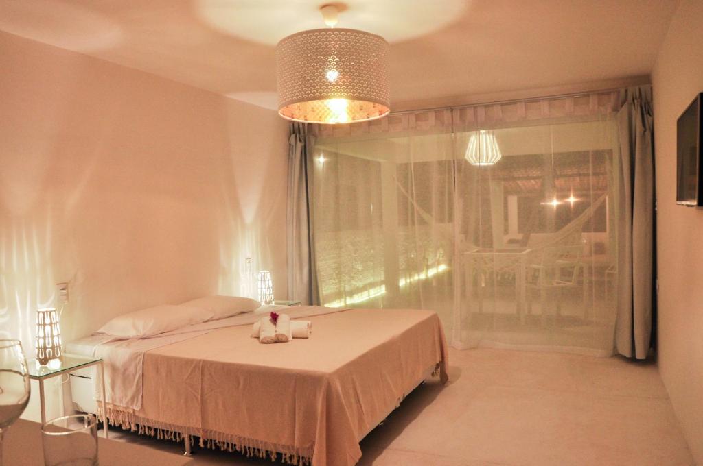 een slaapkamer met een bed met twee knuffels erop bij Vilamaré in São Miguel do Gostoso