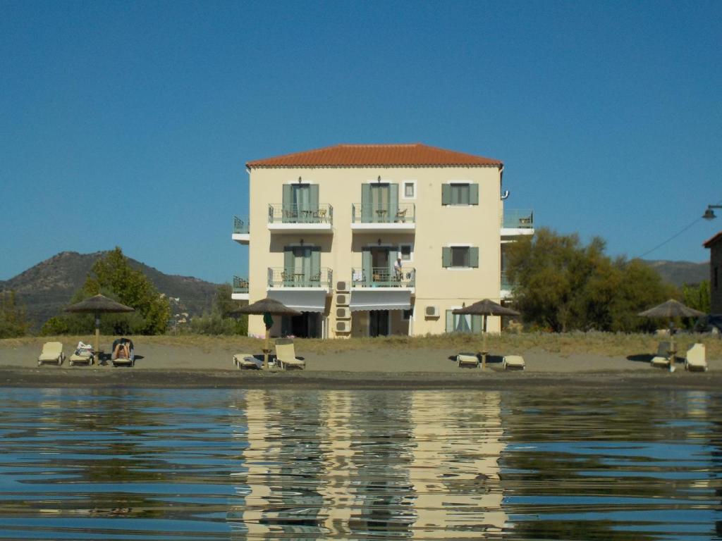 un edificio en la playa con sillas y agua en Akti Kamares, en Kamáres
