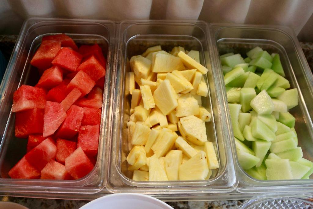 three plastic containers filled with fruits and vegetables at Southernmost Point Guest House & Garden Bar in Key West