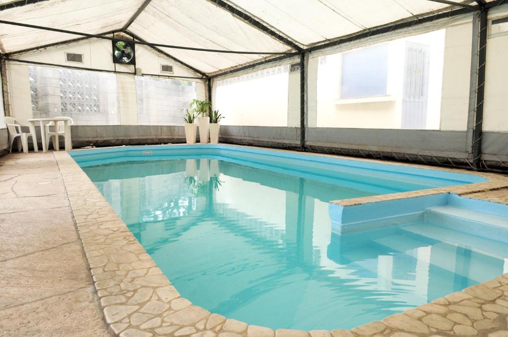 una piscina en una marquesina con agua azul en Hotel Temu en Villa Carlos Paz