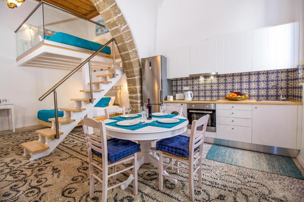 a kitchen with a table and chairs and a spiral staircase at The red door in Koskinou in Koskinou