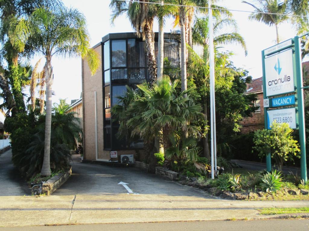 un bâtiment avec des palmiers en face de celui-ci dans l'établissement Cronulla Motor Inn, à Cronulla