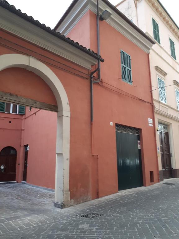an orange building with an archway on a street at Il Cortile in Iesi